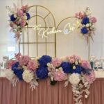 Neon P.S. Kocham Cię na ściance kwiatowej dekoracja weselna